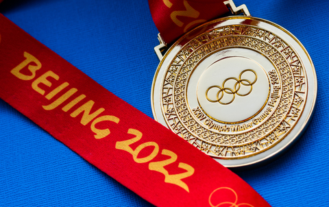 Beijing 2002 Winter Olympics gold medal with red ribbon on blue background