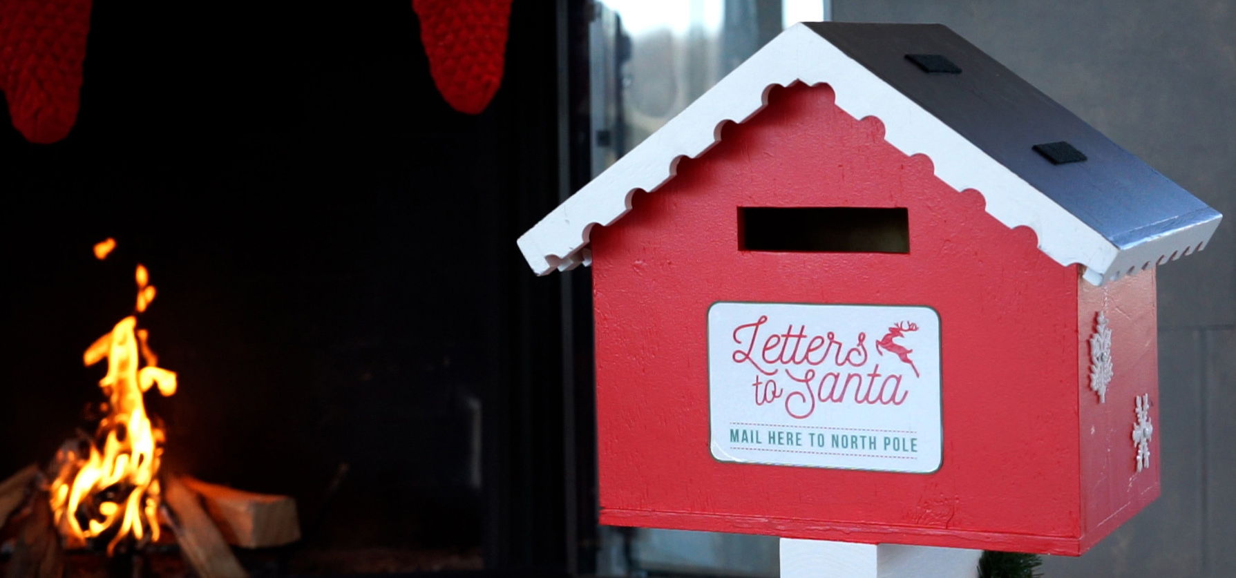 A mailbox to send Letters to Santa with a fire in the background