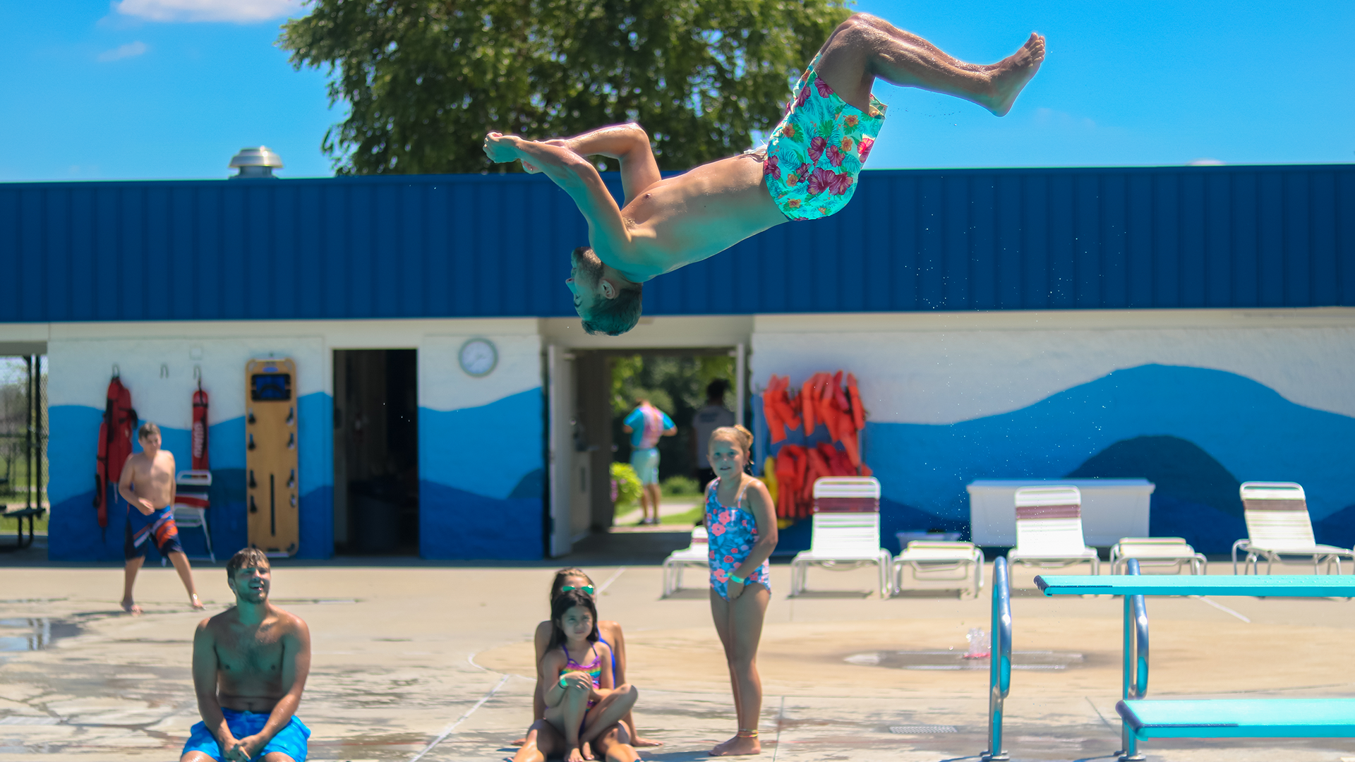 A man does a backflip off the diving board at Oregon Trail Pool