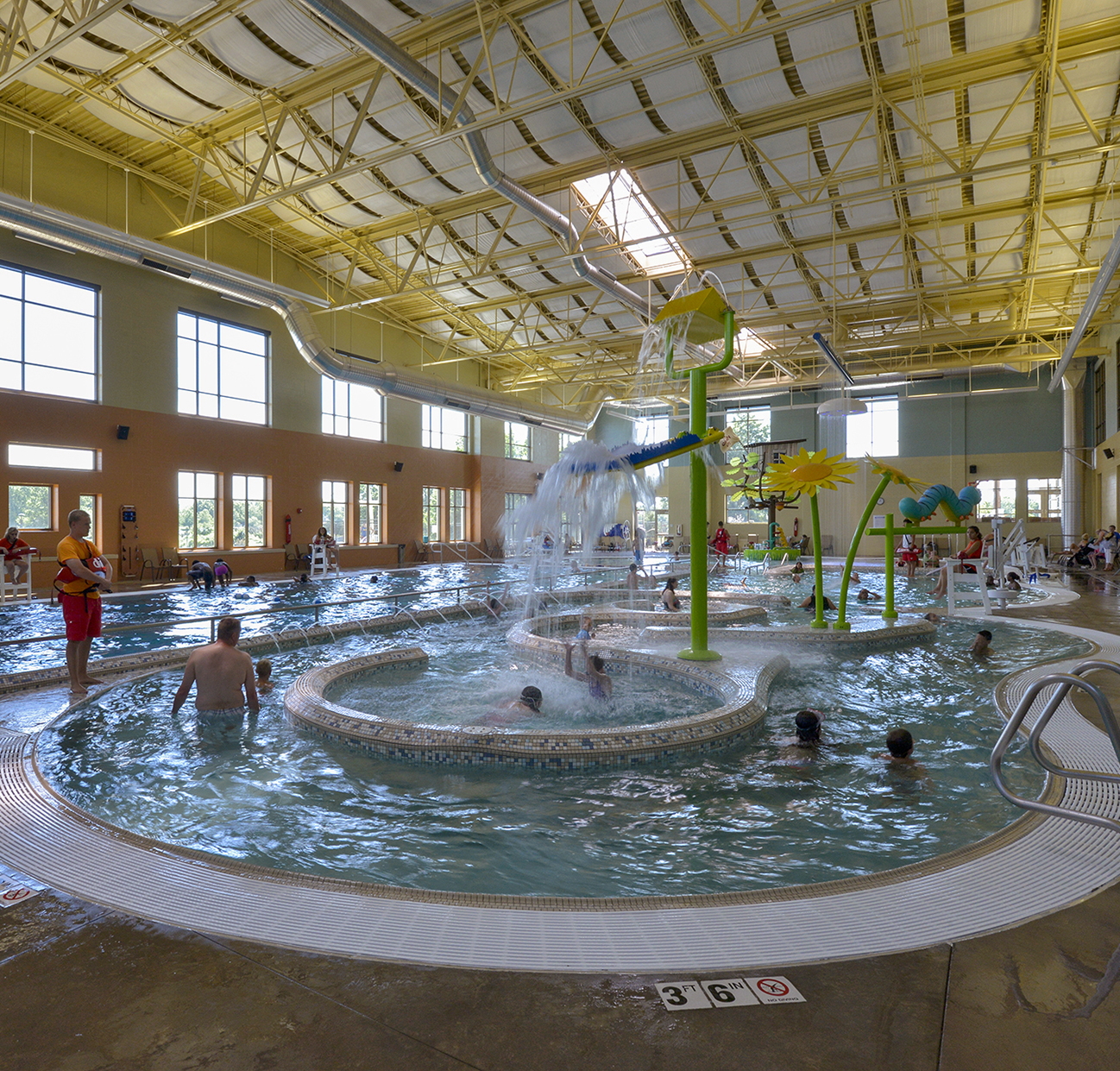 Swimmers in the water of the riverwalk area at the Olathe Community Center pool.