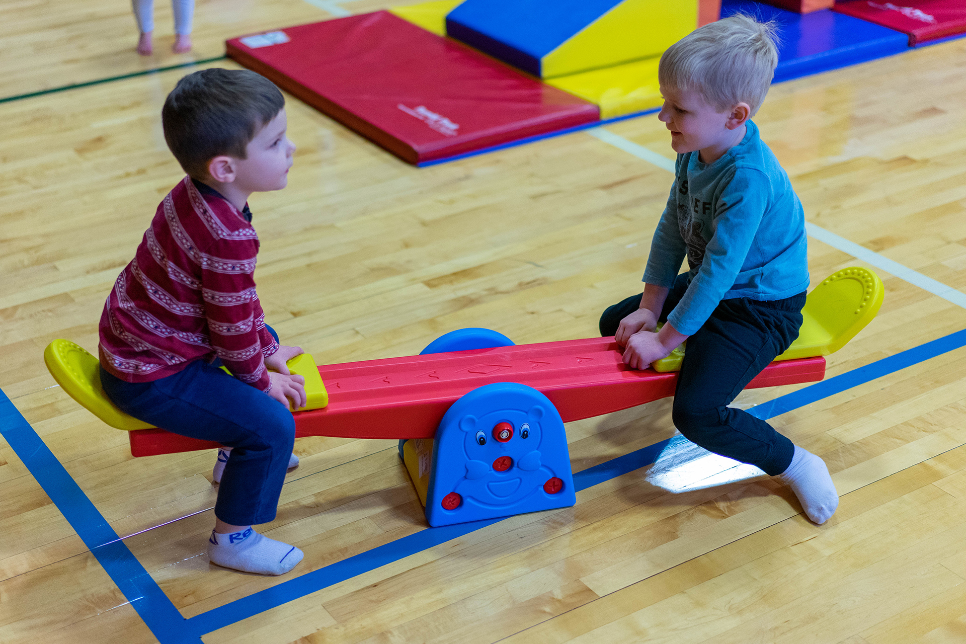 Two children play on a teeter-totter