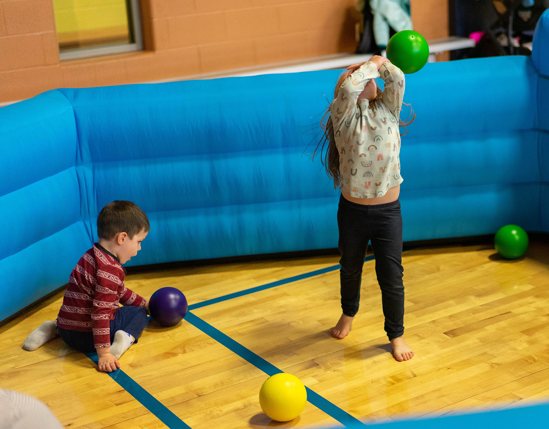 Two children play with dodgeballs