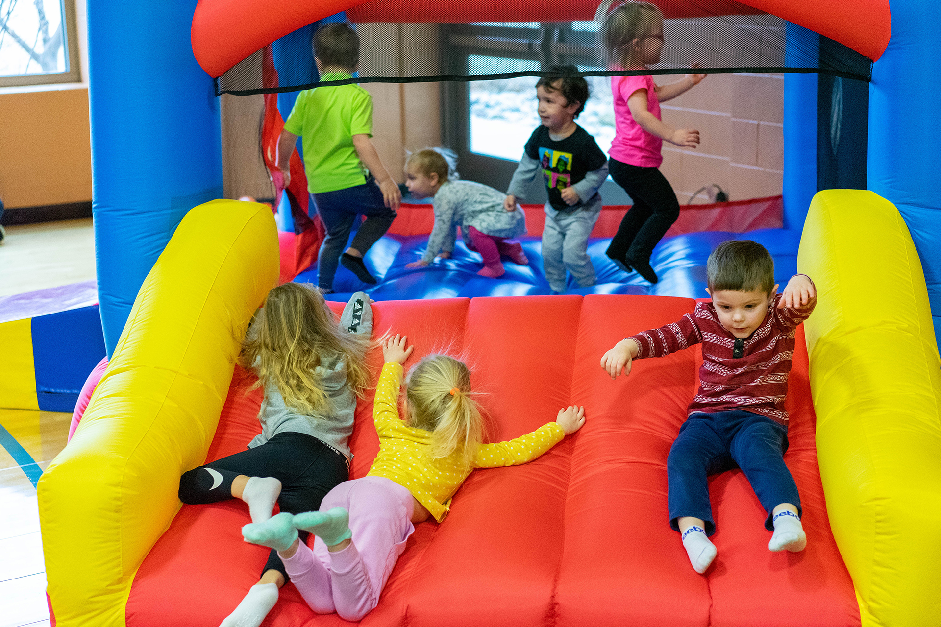 Multiple children playing and sliding down an inflatable play structure