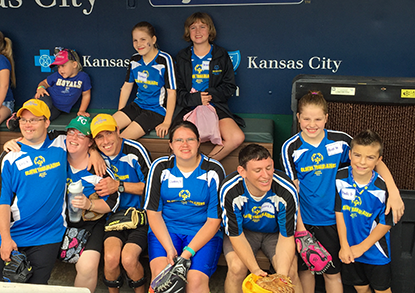 A group of Special Olympics participants sit in a dugout at the Royals