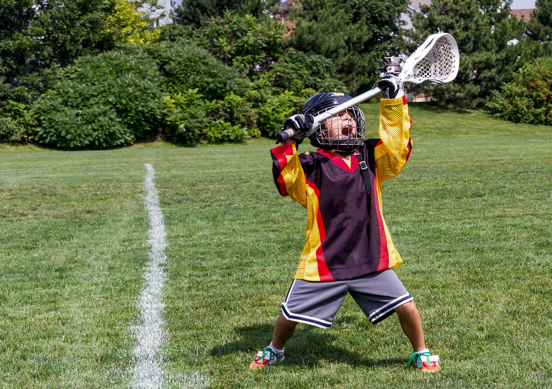 A young boy plays lacrosse