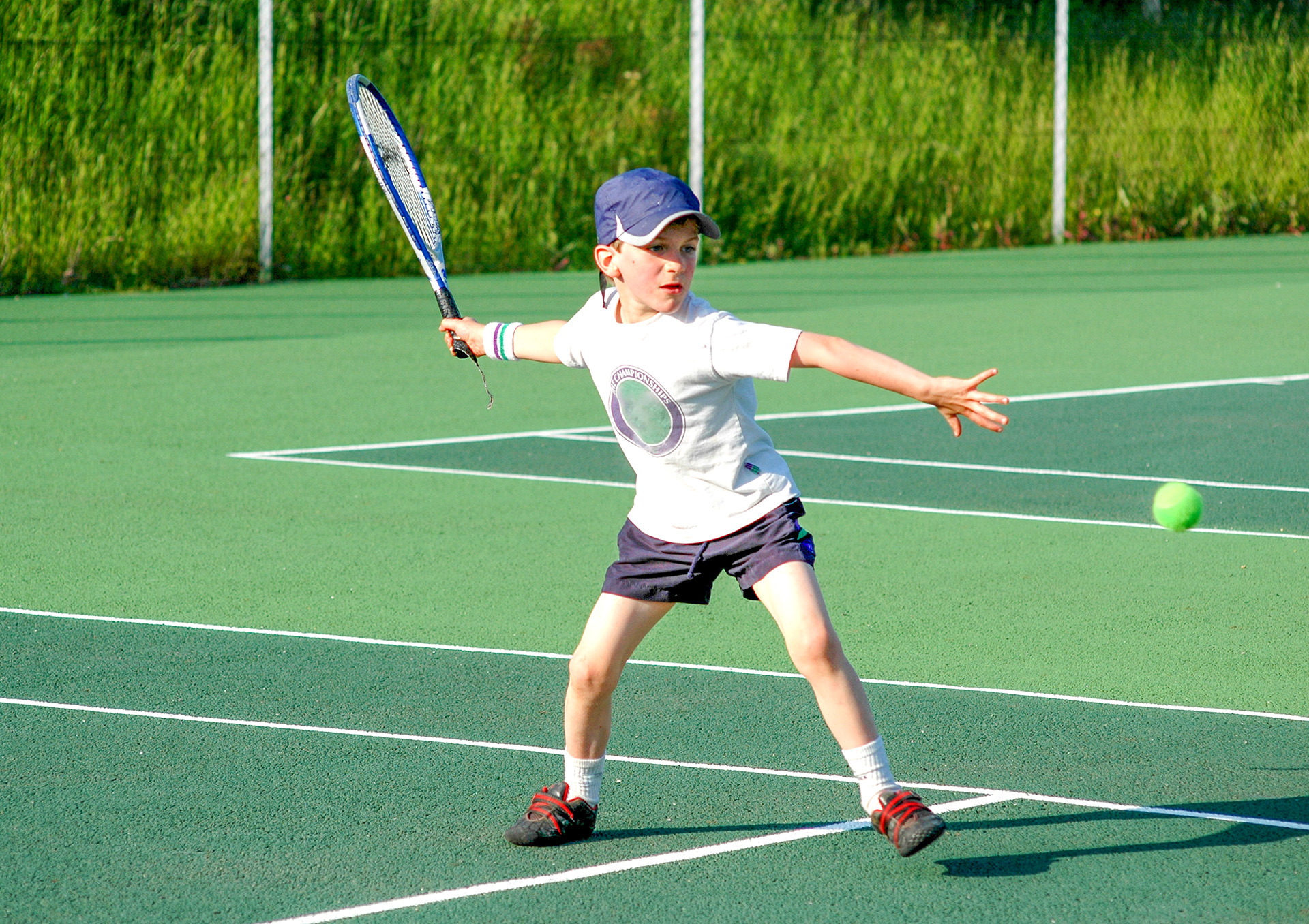 A young boy plays tennis