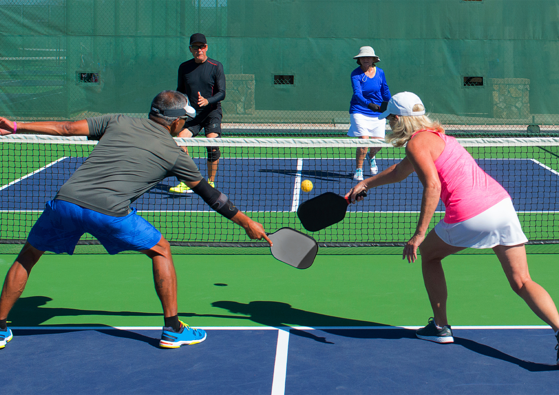 A group of adults playing pickleball