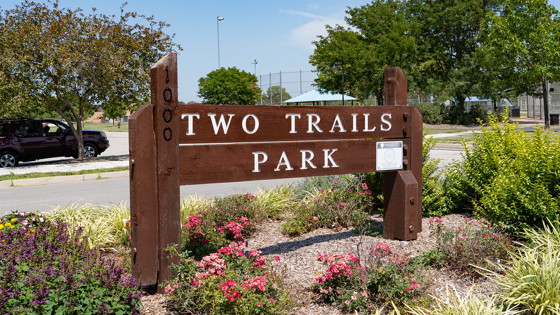 Wooden sign that states "Two Trails Park" and "1000"