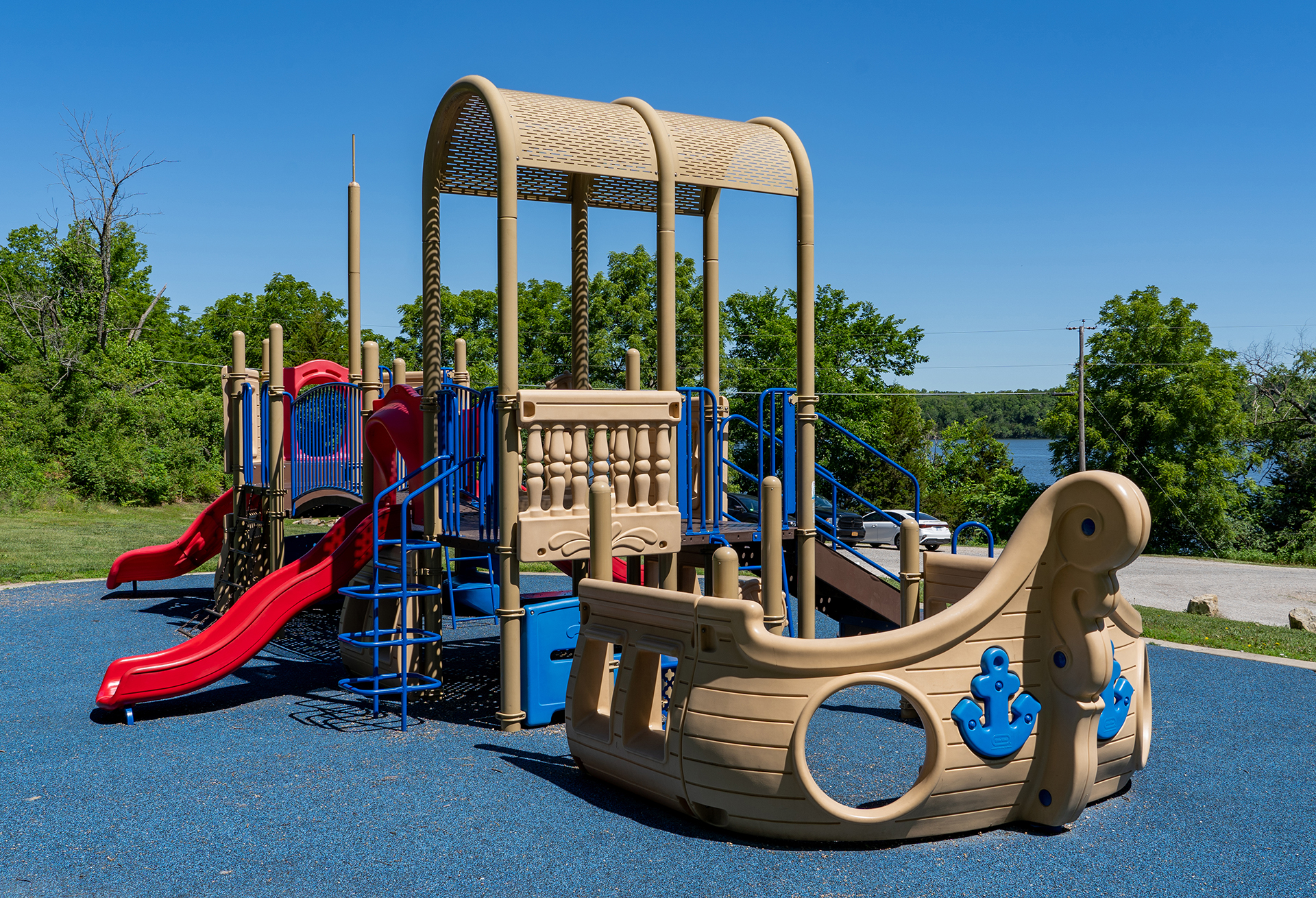 Red, blue, and tan ship shaped playground structure