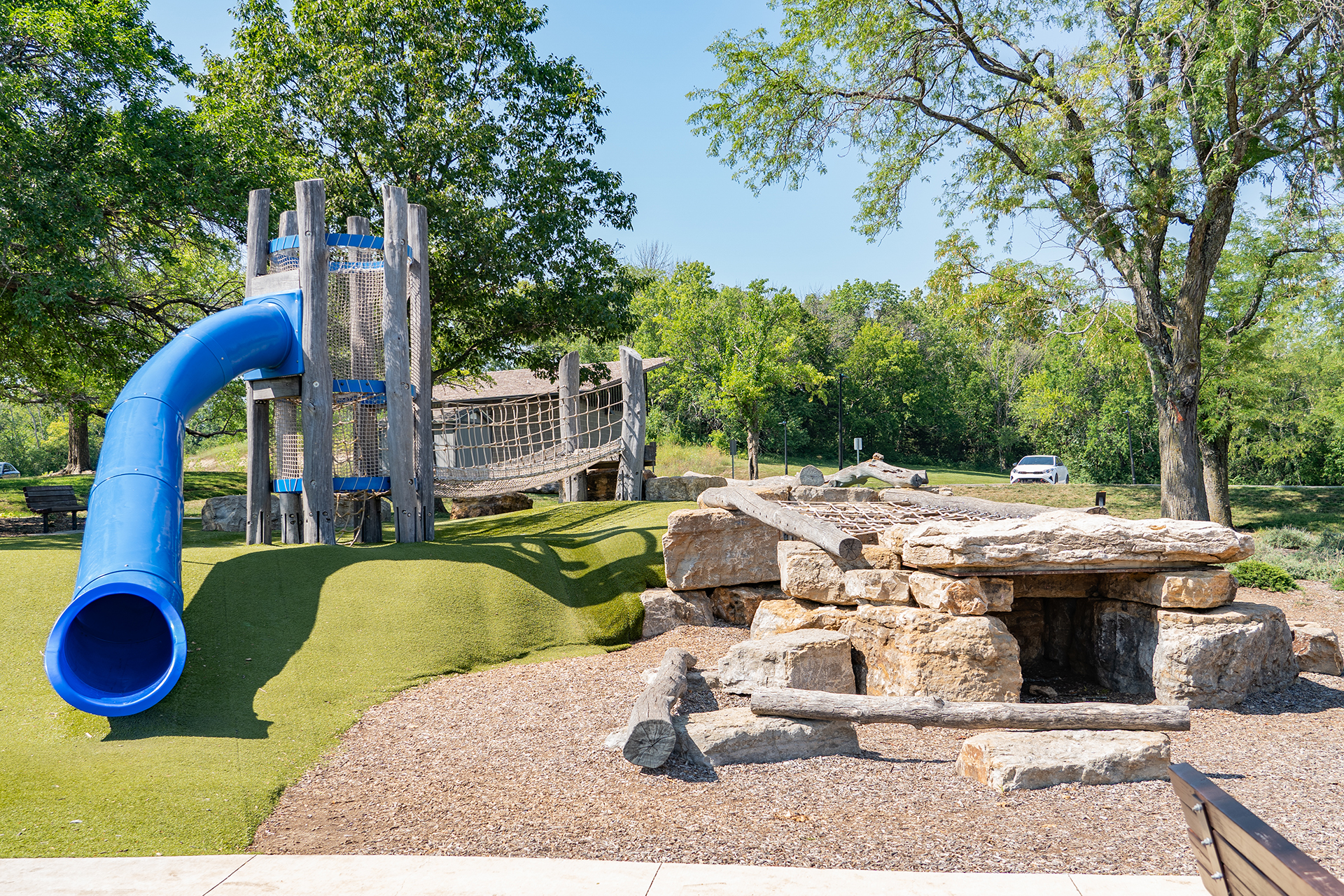 Playground with tall blue side and stone play cave